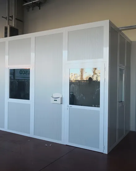 Box ufficio in pannello bianco con porta e finestre dentro un capannone