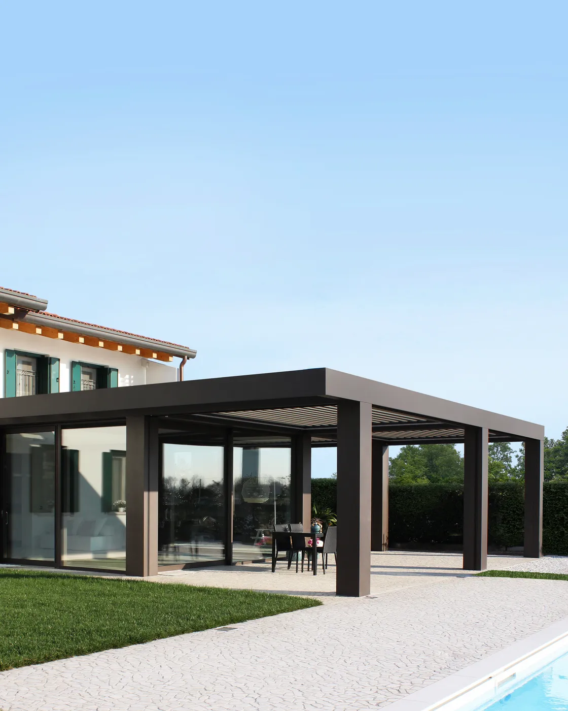 Pergola con copertura a lame accanto a una piscina